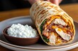 © Sanchai - Person preparing a chicken and spinach wrap with a side of cottage cheese, showcasing a high-protein diet lunch idea