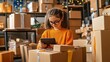 © Pual GotoMars - Young girl with tablet surrounded by cardboard boxes in a warehouse.
