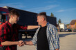 © phoenix021 - Fleet manager and driver shaking hands , or hands shake of two truckers collogues smiling and talking