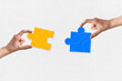 © MR.DEEN - Two hands holding jigsaw puzzle pieces, teamwork, concept of business collaboration, isolated on white paper background