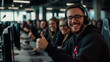 © Maksym - A wide shot of a vibrant call center office, showing a group of technical support staff wearing headsets, smiling happily and giving thumbs up while seated at their computers, with