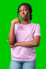 Thoughtful woman pondering in front of a bright green background during a casual moment