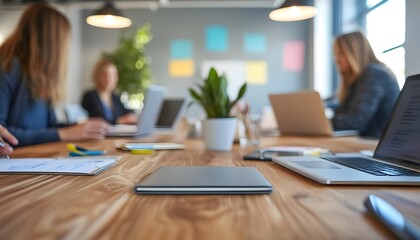 Close-up of a Desk in an Office with Blurred Background of People Working