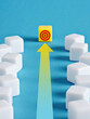 © Cagkan - Yellow cube leading with arrow to target surrounded by white cubes