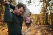 © Halfpoint - Father and girl are playful during walk in autumn forest. Dad and girl having fun outdoors.