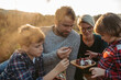 © Halfpoint - Portrait of family with two kids having picnic in autumn nature, eating fruits and cheese.