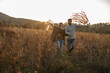 © Halfpoint - Couple in love on a walk in autumn forest. Husband holding wife hand, holding wreath with ribbons.