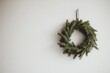 © ChaoticMind - A classic evergreen wreath hangs gracefully on a plain backdrop, offering a sense of calm and tradition through its lush foliage and artisanal construction.