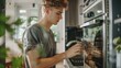 © Imsuniyah - Young Man Cleaning a Modern Stainless Steel Oven in a Kitchen