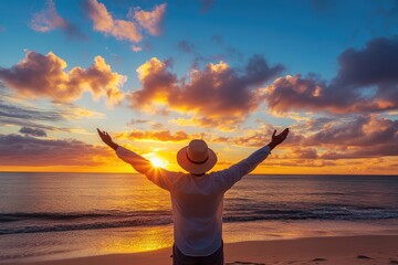 Man stands with arms raised at sunset. Perfect for representing a sense of freedom, peace, and hope.