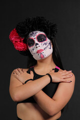 Young Mexican woman made up as Catrina or skull with flower crown to celebrate the Day of the Dead in Mexico