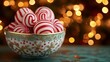 © Pixels  - Candy cane hot chocolate bombs in a decorative bowl, sitting on a mint table with a deep gold backdrop and twinkling Christmas lights, copy space, Merry Christmas background, festive candy promo