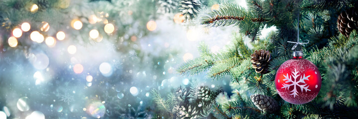 Wall Mural - christmas - red sphere hanging on fir tree in abstract snowy background