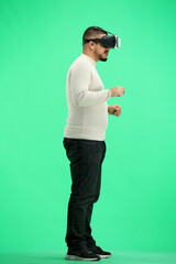 Canvas Print - Man, full-length, on a green background, wearing VR glasses