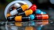© familymedia - A vivid array of colorful capsules and pills spilled over a reflective surface, showcasing their variety, with emphasis on health and medicinal properties.