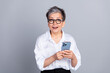 © deagreez - Photo portrait of lovely senior lady hold device excited dressed stylish formalwear isolated on gray color background