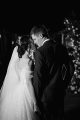 girl and guy against the background of a night wedding arch