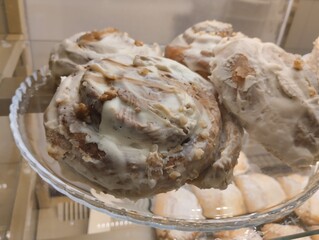 Wall Mural - Cinnamon rolls with cream . Three cream buns lying on a plate in a cafe shop window