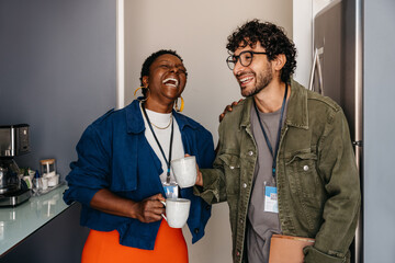 Candid moment: Employees at work sharing a joyful coffee break in the office, fostering friendship and laughter