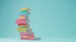 © Selvi - A stack of colorful books against a light blue background.