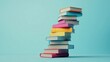 © Selvi - A stack of colorful books leaning precariously on a light blue background.