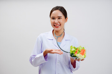 Smiling female doctor holding vegetable salad Health care.