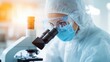 © Intelligent Horizons - Portrait of a laboratory technician in a white coat and protective gear using a microscope to closely examine a sample of cell cultured meat