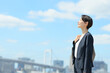 © Peak River - 青空の中に立つビジネスウーマン