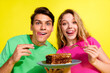 © deagreez - Photo of two nice young people eat large piece cake wear t-shirt isolated on bright yellow color background