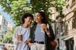 © Bliss - A happy couple laughs together, sipping coffee, while exploring their vibrant city surroundings.