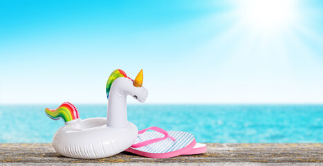 Poster - lip flops and a floating flamingo placed on a table with a sunny sea