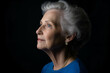© Rohit k  - Serene senior woman with blue eyes and gray hair gazes up against a black backdrop, radiating wisdom and contentment. Aging gracefully, she embodies hope and natural beauty