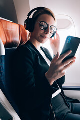Wall Mural - travel tourism technology and air flights concept, intelligent woman sitting in plane with modern sm