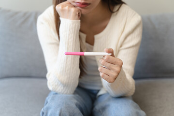 close-up young woman checking on the pregnancy test and the result is positive.