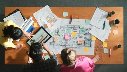 Top view of engineer working together to design building construction while standing at meeting table with blueprint and notes. Top view of interior designer choosing color from palettes. Symposium.