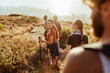 © Marko Geber - Group of friends hiking at sunset by the ocean
