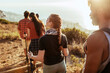 © Marko Geber - Group of friends hiking at sunset by the ocean