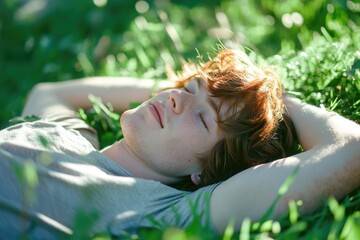 Sticker - A young man is lying down in a lush green meadow, eyes closed, soaking up the sun.