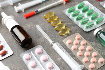 Wall Mural - Pharmacist. Different pills, syringes and bottle of medical drops on grey table, closeup