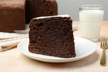 Piece of tasty chocolate sponge cake served on light table, closeup