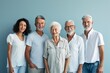 © Iigo - Portrait of a group of smiling senior people standing together against blue background