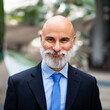 © Minerva Studio - Smiling senior businessman posing outdoors in urban city center