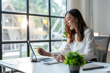 Wall Mural - businesswoman working with digital tablet and using calculator in office