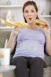 © auremar - portrait of pregnant woman holding a plate of junk food