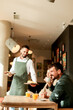 © BGStock72 - Waiter serves delicious vegetarian dishes to cheerful diners in a vibrant café during a sunny afternoon