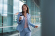 © Dexon Dee - Portrait of happy businesswoman walking outdoor and holding cup of coffee