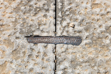 A metal bracket holds antique stone blocks together. Secrets of ancient architecture