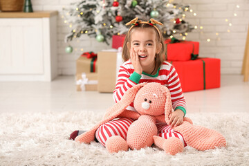 Wall Mural - Cute little girl with toy bunny at home on Christmas eve