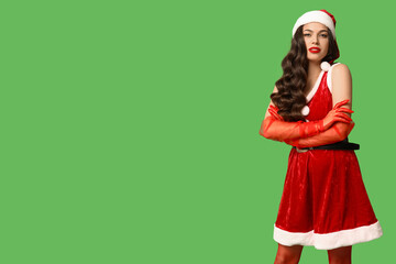 Sticker - Beautiful young sexy woman dressed as Santa on green background