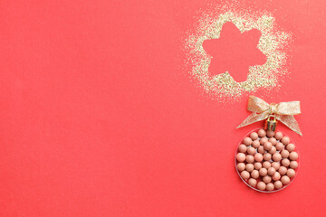 Poster - Christmas ball made with blush and glitter on red background, top view. Space for text